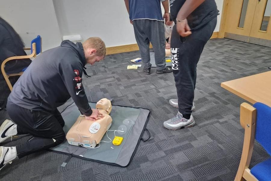 man doing cpr on dummy First aid course in derby